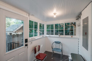A pair of vintage chairs beside the windows on the sun porch