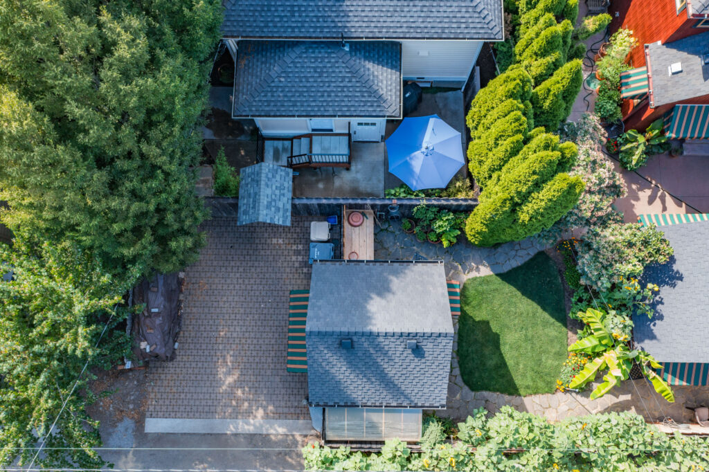 Overhead view of the fenced back yard at Campus Cottage, with the patio and gas grill along the fence