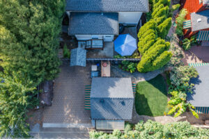 Overhead view of the fenced back yard at Campus Cottage, with the patio and gas grill along the fence